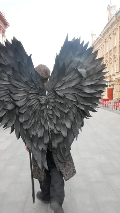 Vertical video: Unrecognizable actor - dark angel with black wings walks down th Stock Footage 281566223