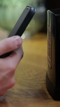 Vertical video. Unrecognizable man scanning QR code on table in restaurant .. Fotos de archivo