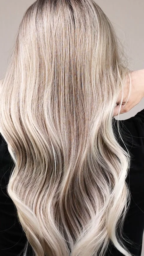 Vertical video of unrecognizable model with long blond curly hair in slow motion Stock Footage 281917543