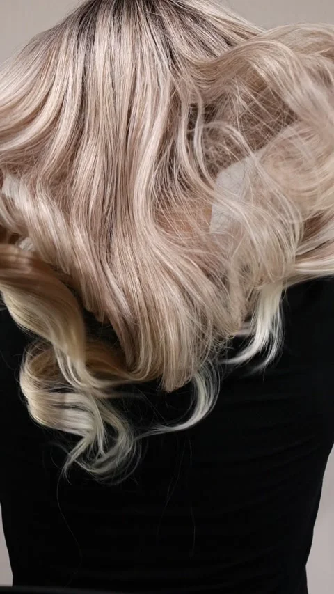 Vertical video of unrecognizable model with long blond curly hair in slow motion Stock Footage 283060422