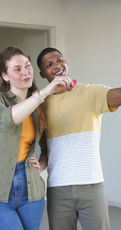 Vertical video: Upon entering empty room couple holding phone and key fob Stock Footage 346718780