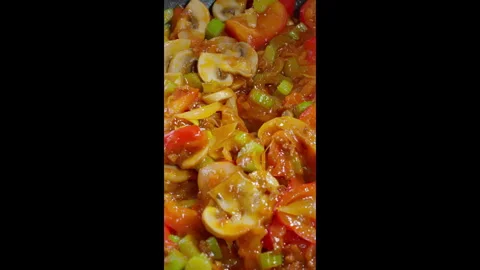 Vertical video. Various vegetables are stewed in a pan. Stock Footage 302585625