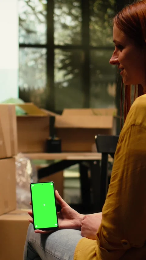 Vertical Video Vertical chroma key on mobile phone with people unpacking Stock Footage 343349098