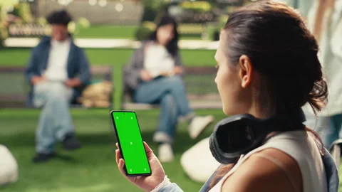 Vertical Video Vertical green screen mockup on smartphone held by young adult Stock Footage 340802236