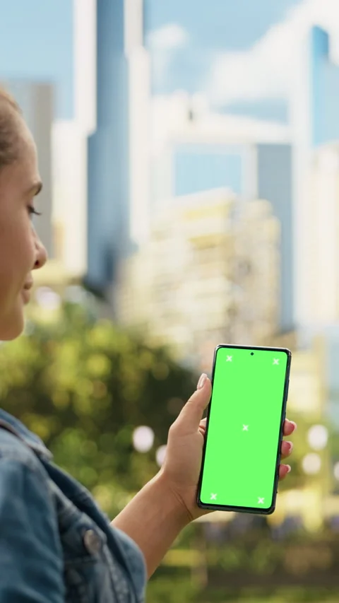 Vertical Video Vertical green screen mockup on phone held by casual woman in Stock Footage 344379778