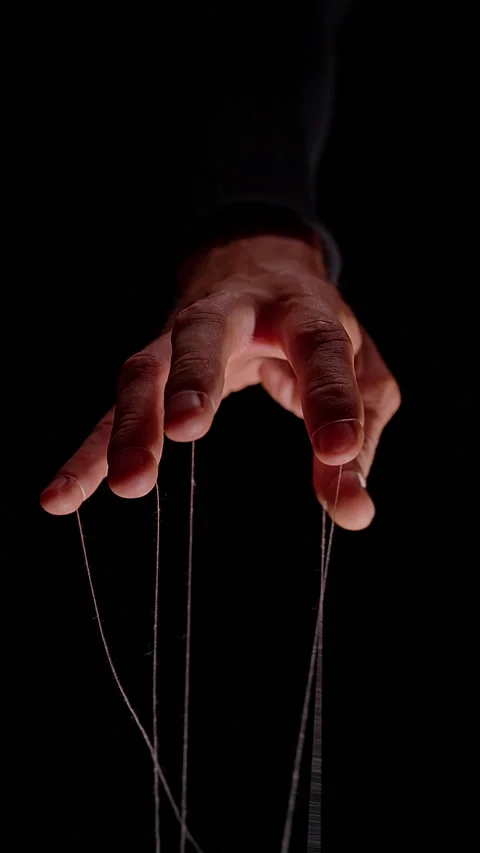 Vertical video. Vertical Low Angle View of Sinister Puppeteer Hand Pulling Strin Stock Footage 341421310