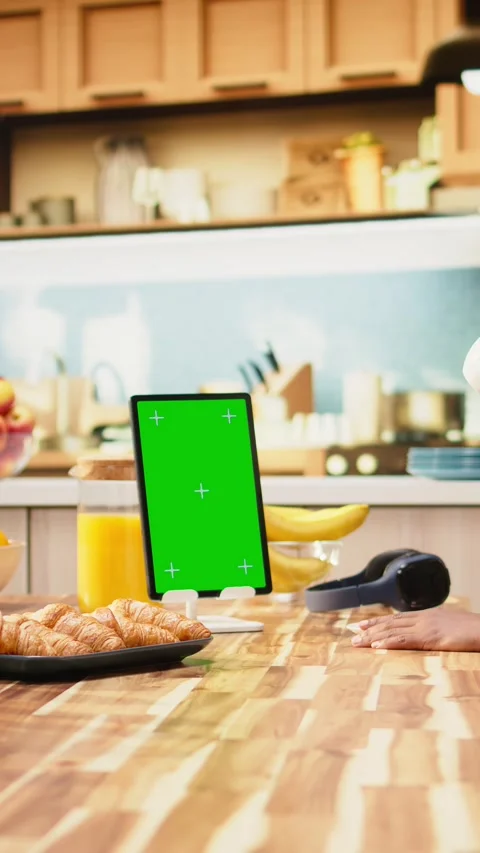 Vertical Video Vertical mockup green screen on tablet in kitchen at wooden table Stock Footage 344530144