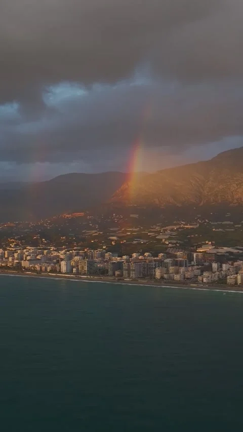 Vertical Video: Vibrant Rainbow and Stunning Sunset Illuminate the Urban Skyline 库存影片 344275465