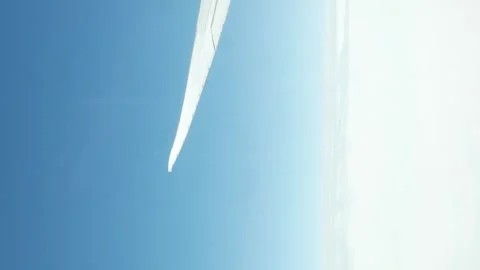 Vertical video view through plane window with view of airplane wing over pu.. Video stock 335584116