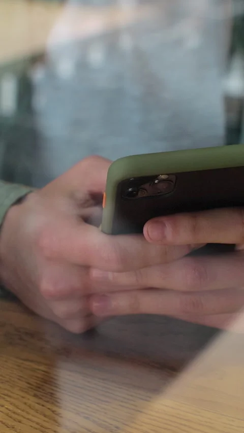 Vertical video. View through window of businessman chat on smartphone Stock Footage 345239026