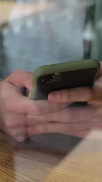Vertical video. View through window of businessman chat on smartphone in co.. Stock Photos