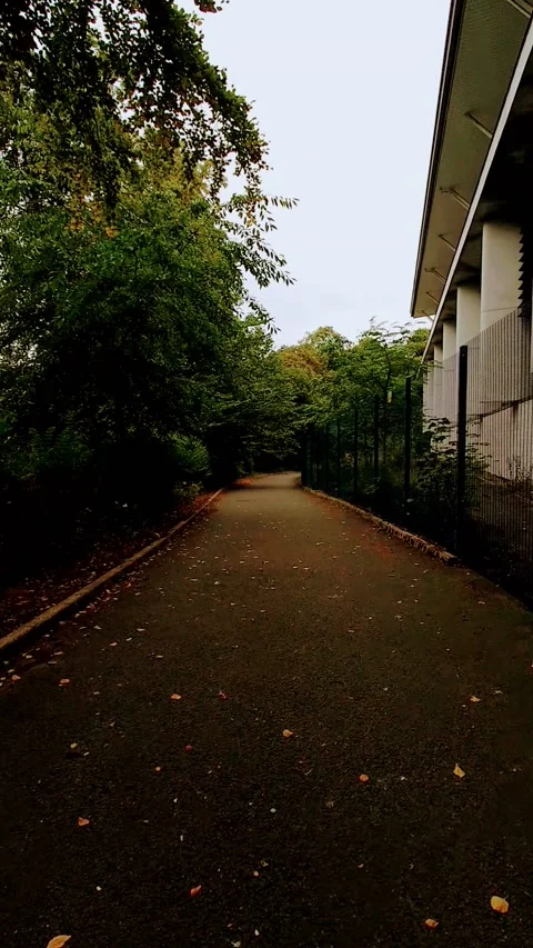 Vertical Video. Walking a path next to a modern building. Stock Footage 160080495