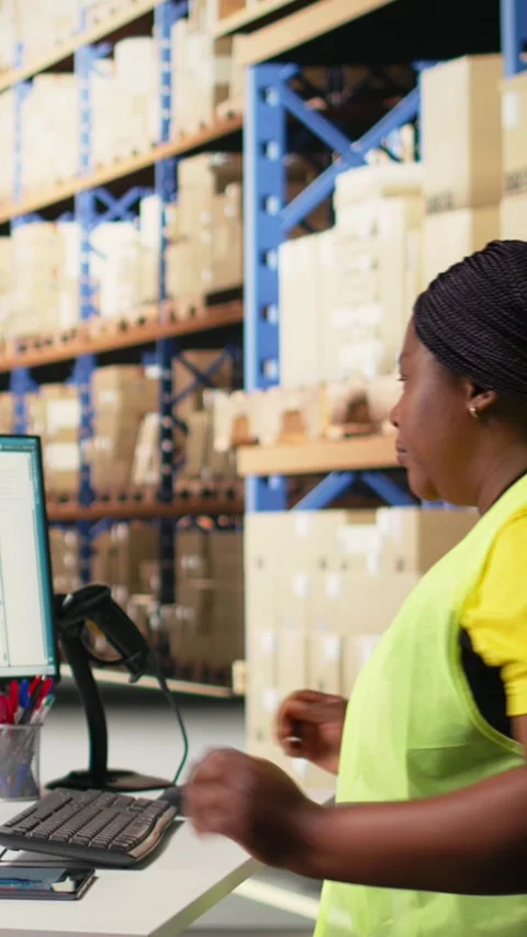 Vertical Video Warehouse employee using package tracking software on computer Stock Footage 312650944