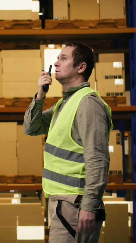 Vertical Video Warehouse operator reporting parcel status via two-way portable Stock Footage 333090615