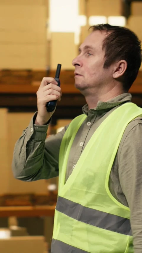 Vertical Video Warehouse operator reporting parcel status via two-way portable Stock Footage 333091795