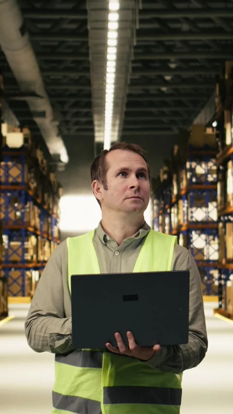 Vertical Video Warehouse staff member in facility checking pallets and packages Stock Footage 333090401