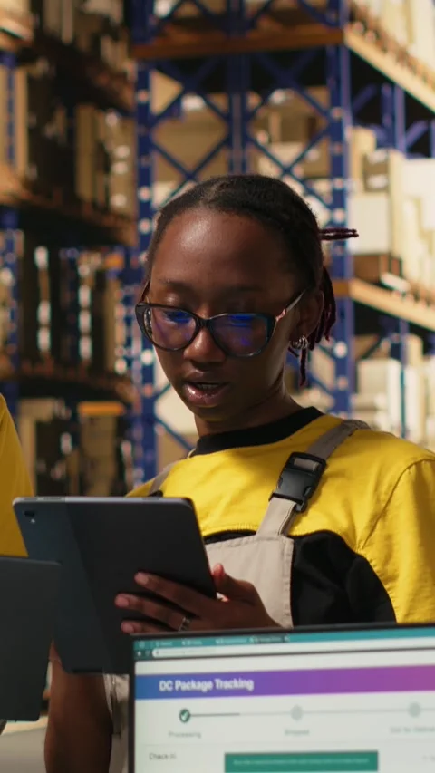 Vertical Video Warehouse staff overseeing parcels tracking info on laptop and 스톡 동영상 315189853