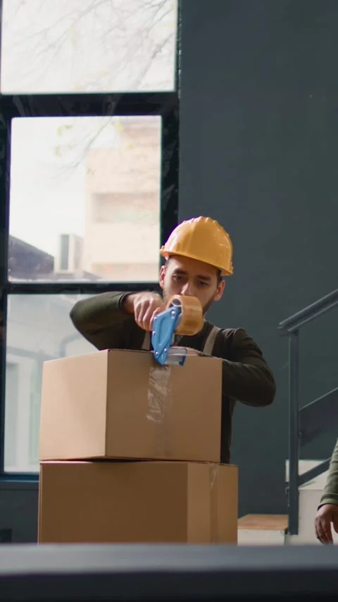 Vertical video Warehouse trainee seals boxes parcels 스톡 동영상 249528954