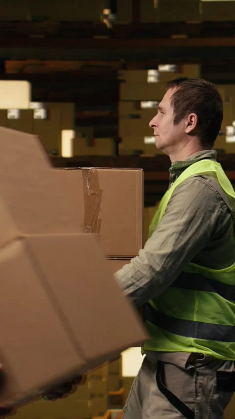 Vertical Video Warehouse worker stacking cargo pallets in distribution hub Stock Footage 333090698