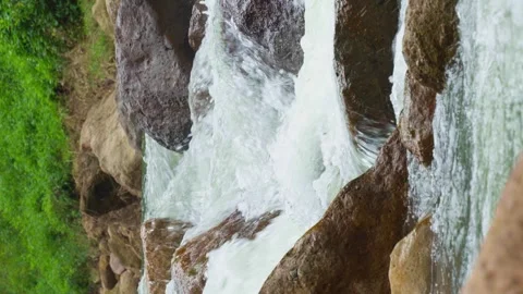 Vertical video, Waterfall flowing through rock layers into a pool Stock Footage 282518151