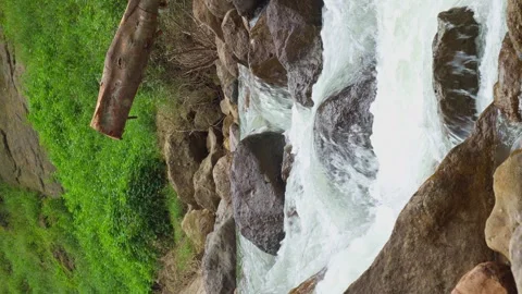 Vertical video, Waterfall flowing through rock layers into a pool Stock Footage 282518194