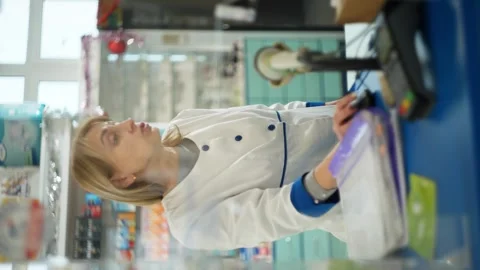 Vertical video in which the pharmacy assistant explains the details of the work Stock-Footage 265065499