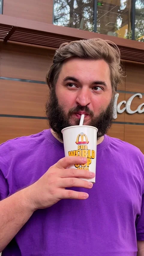 Vertical video. White fat man with beard drinks sweet soda water drink Stock Footage 339038939