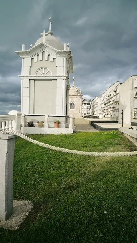 Vertical video of a white mausoleum at the Luarca cemetery with moving clouds Video stock 322046129