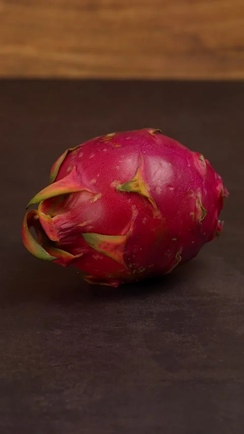 Vertical video, Whole uncut dragon fruit, on a dark table Stock Footage 281035489