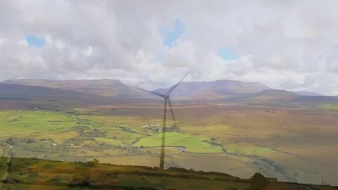 Vertical video: Wind turbine rotating, breeze moving blades across valley, Vídeos de archivo 332746829