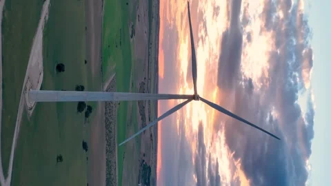 Vertical video of a wind turbine turning its blades against the sun Stock Footage 274533645