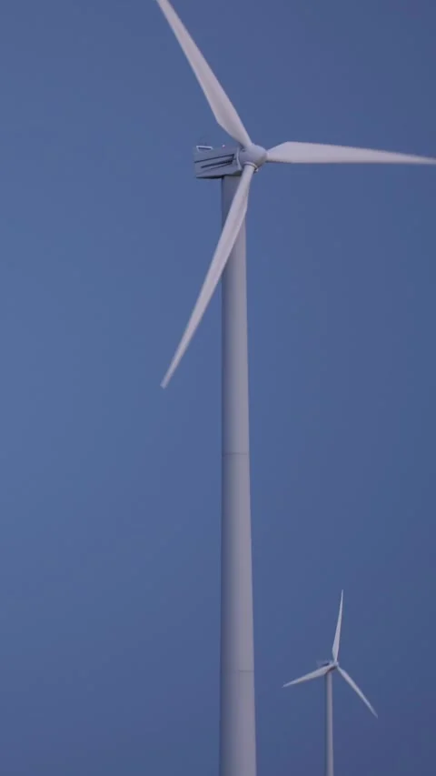 Vertical video. Wind turbines spinning against the blue sky. Stock Footage 247642948