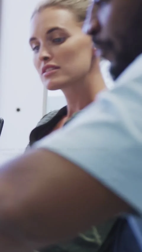 Vertical video: Woman dev speaking, causing code overlay while man dev typing, Stock Footage 331274471
