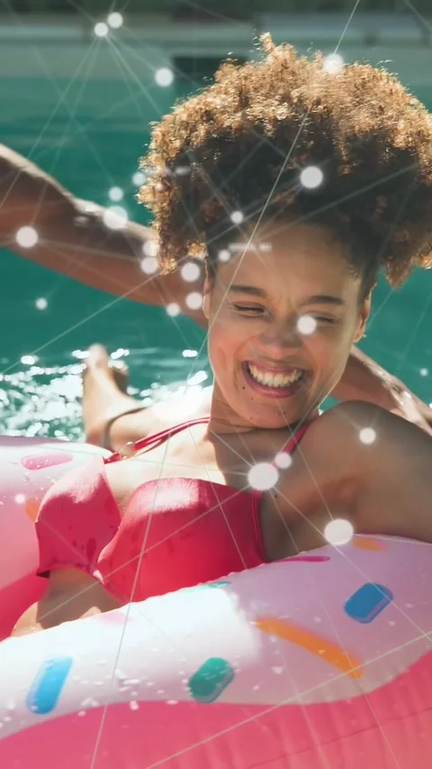 Vertical video: Woman on donut float playing, reaching as man tossing ball, ads Stock Footage 337540678