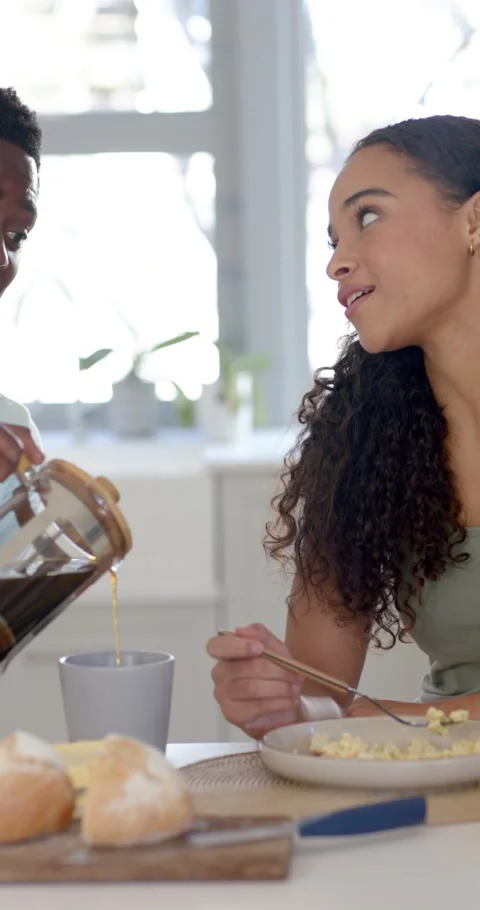 Vertical video: Woman with fork looking while man bringing press, pouring Stock Footage 345130934