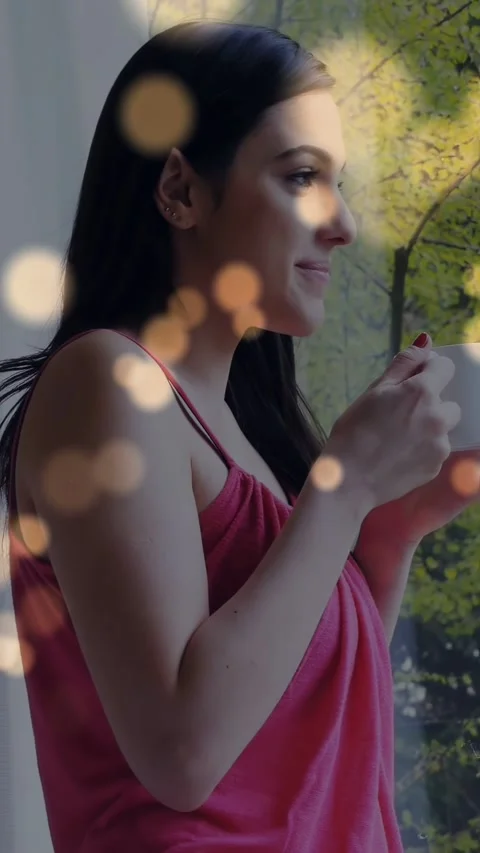 Vertical video: Woman by large window lifting white cup to lips sipping relaxing Stock Footage 340133458