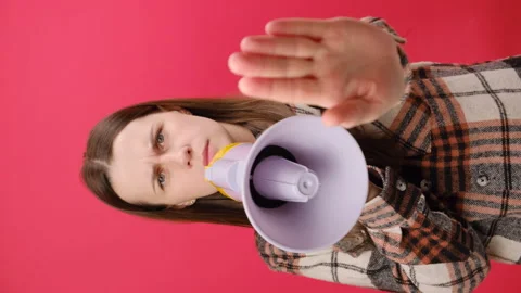 Vertical video of woman making stop gesture, shouting in megaphone to camera Stock Footage 259283492