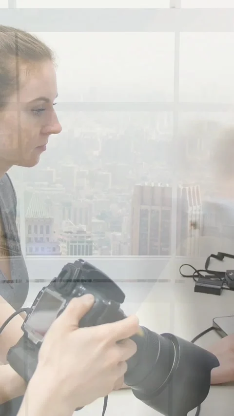 Vertical video: Woman operator checking DSLR, blurred coworker crossing Video stock 329962039
