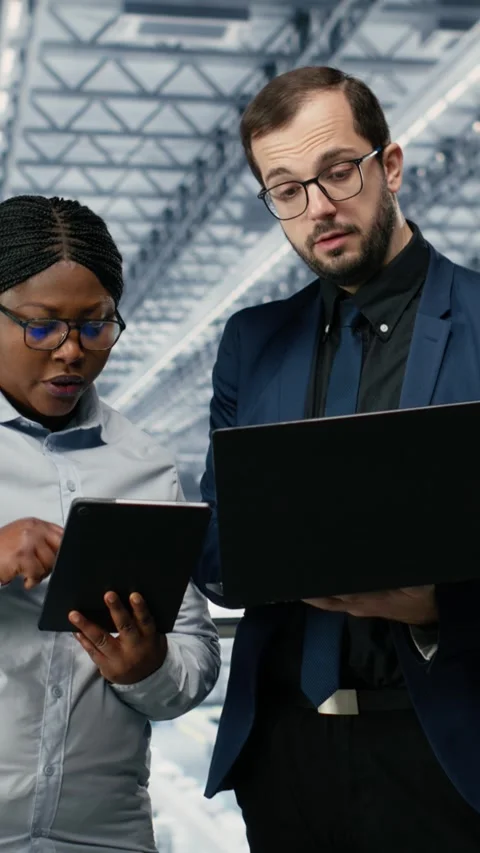 Vertical video Woman optimizes microchip factory workflow with coworker, using 스톡 동영상 333614455