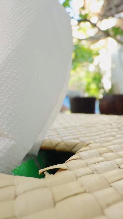 Vertical video. Woman Pulling a Tissue From a Woven Tissue Box at an Outdoor Tro Stock Footage 337026667