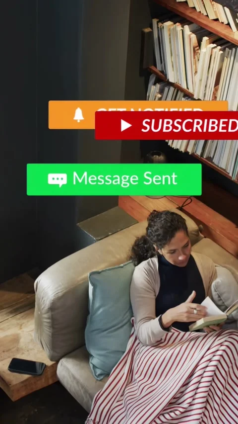 Vertical video: Woman reading on sofa by shelf, phone causing media badges Stock Footage 333745373