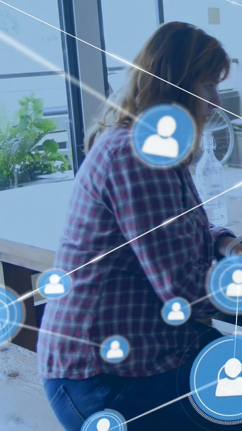 Vertical video: Woman seated using device, starting tech network map with Stock Footage 333513150
