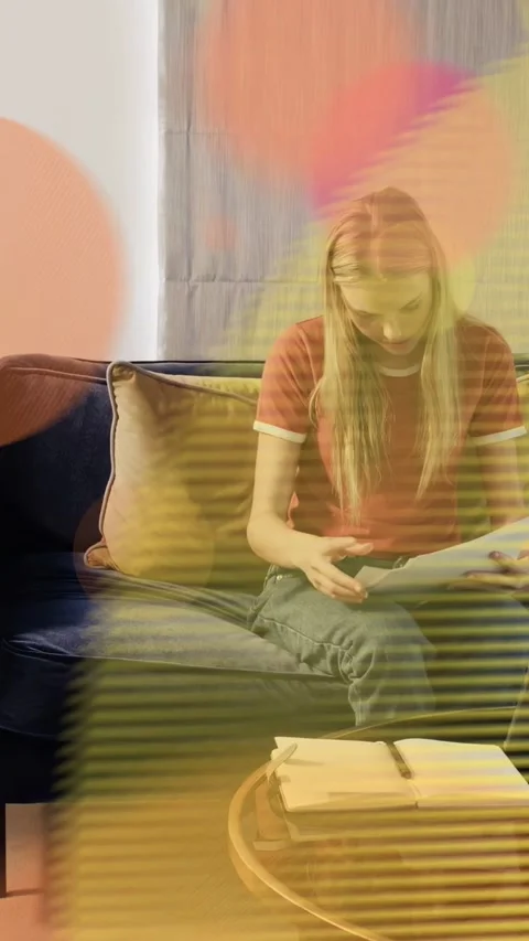 Vertical video: Woman on sofa sorting work papers for filing, mid circles Stock Footage 333633183