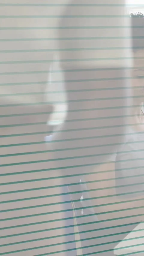 Vertical video: Woman taking notes in class, ruled lines moving, revealing Stockbeeldmateriaal 333744433