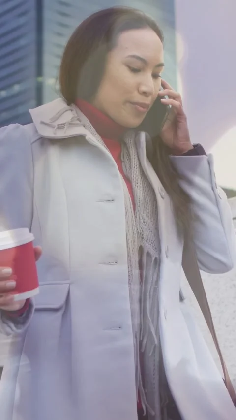 Vertical video: Woman taking work call, camera closing, holding cup, lens flares Stock Footage 333839768
