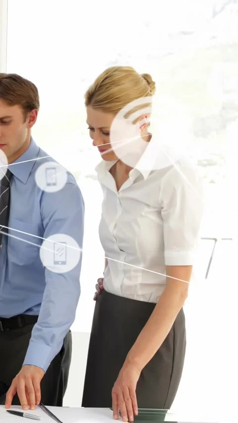 Vertical video: Woman tapping floating interface, man observing, creating mobile Stock Footage 334600775