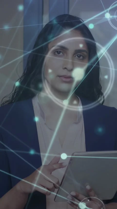 Vertical video: Woman tapping tablet, animating network map, then looking up, Stock Footage 330965664