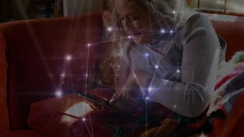 Vertical video: Woman tapping tablet on couch and activating node overlay while 動画素材 332731553