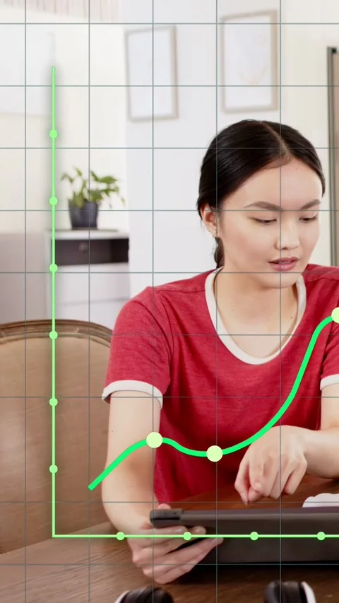 Vertical video: Woman tapping tablet working in tech, guiding graph overlay as Stock Footage 332846544
