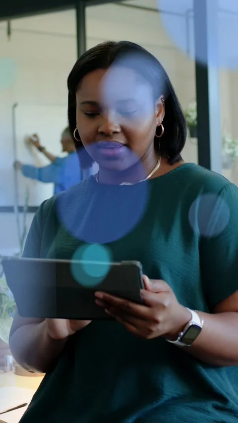 Vertical video: Woman tapping tablet in tech, checking work while dots floating Stock Footage 333821283